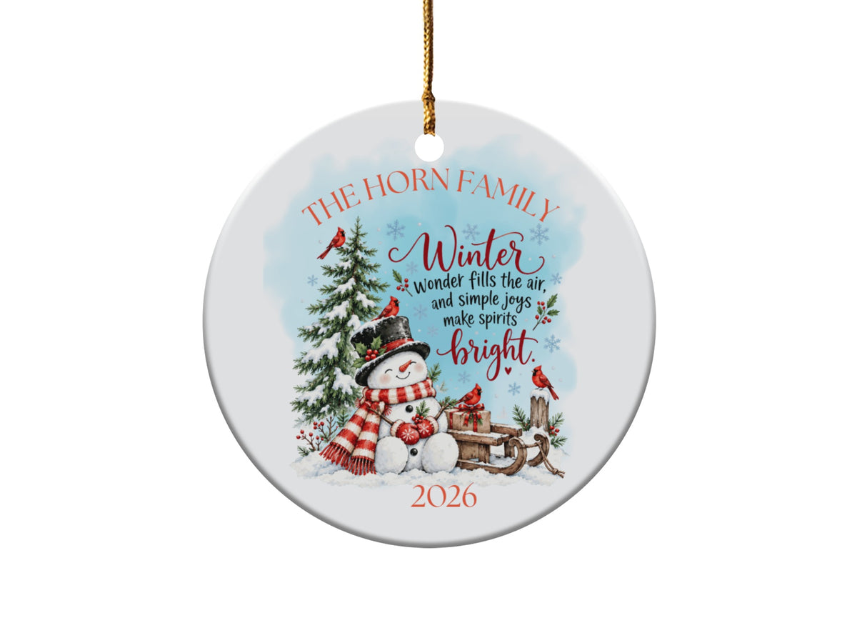 Round ceramic Christmas ornament featuring a snowman, winter scene, cardinals, and the year 2026.