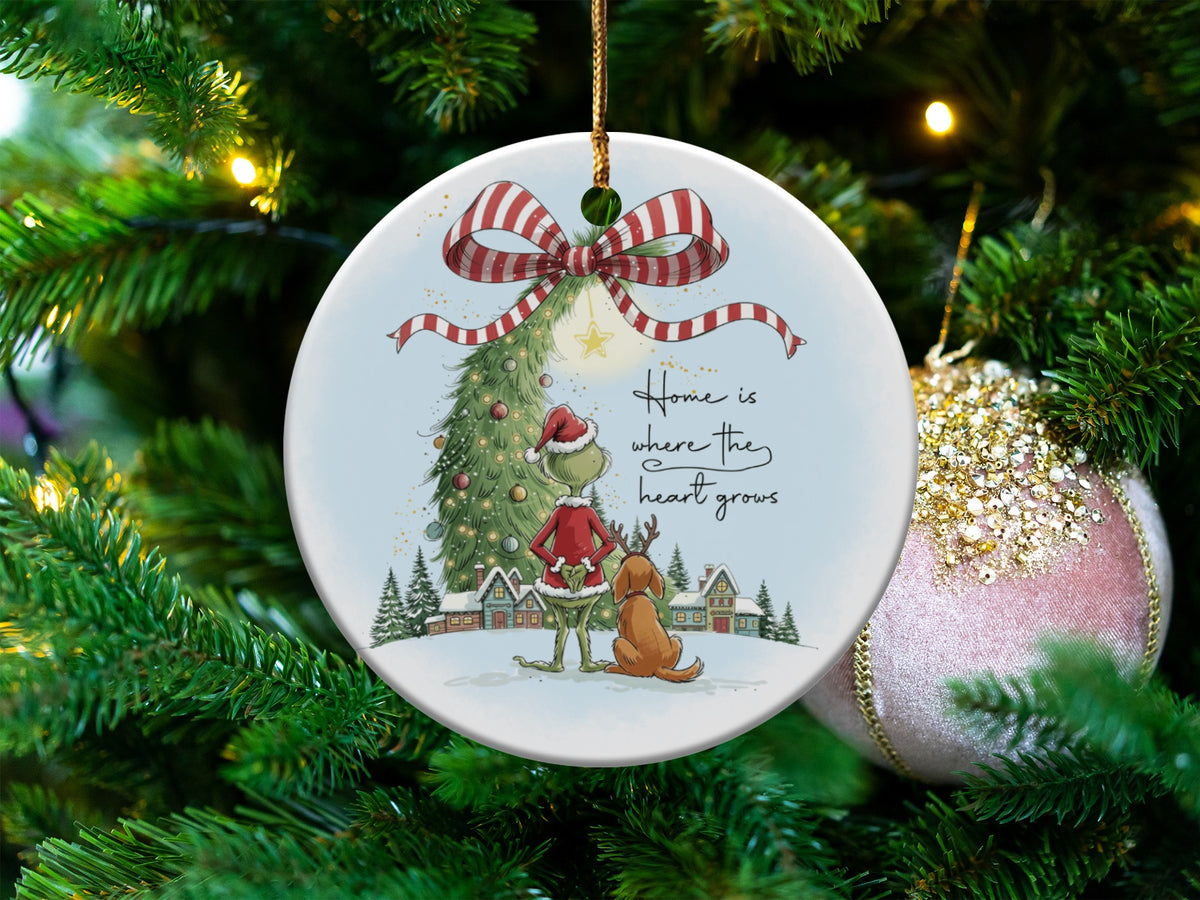Grinch ornament with Max, Christmas tree, snowy village, and text "Home is where the heart grows."