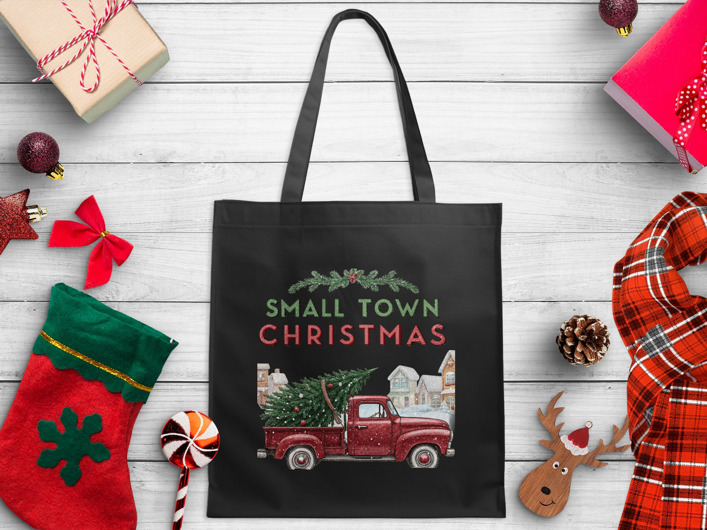 Black tote bag with "Small Town Christmas" text and red truck with tree graphic.