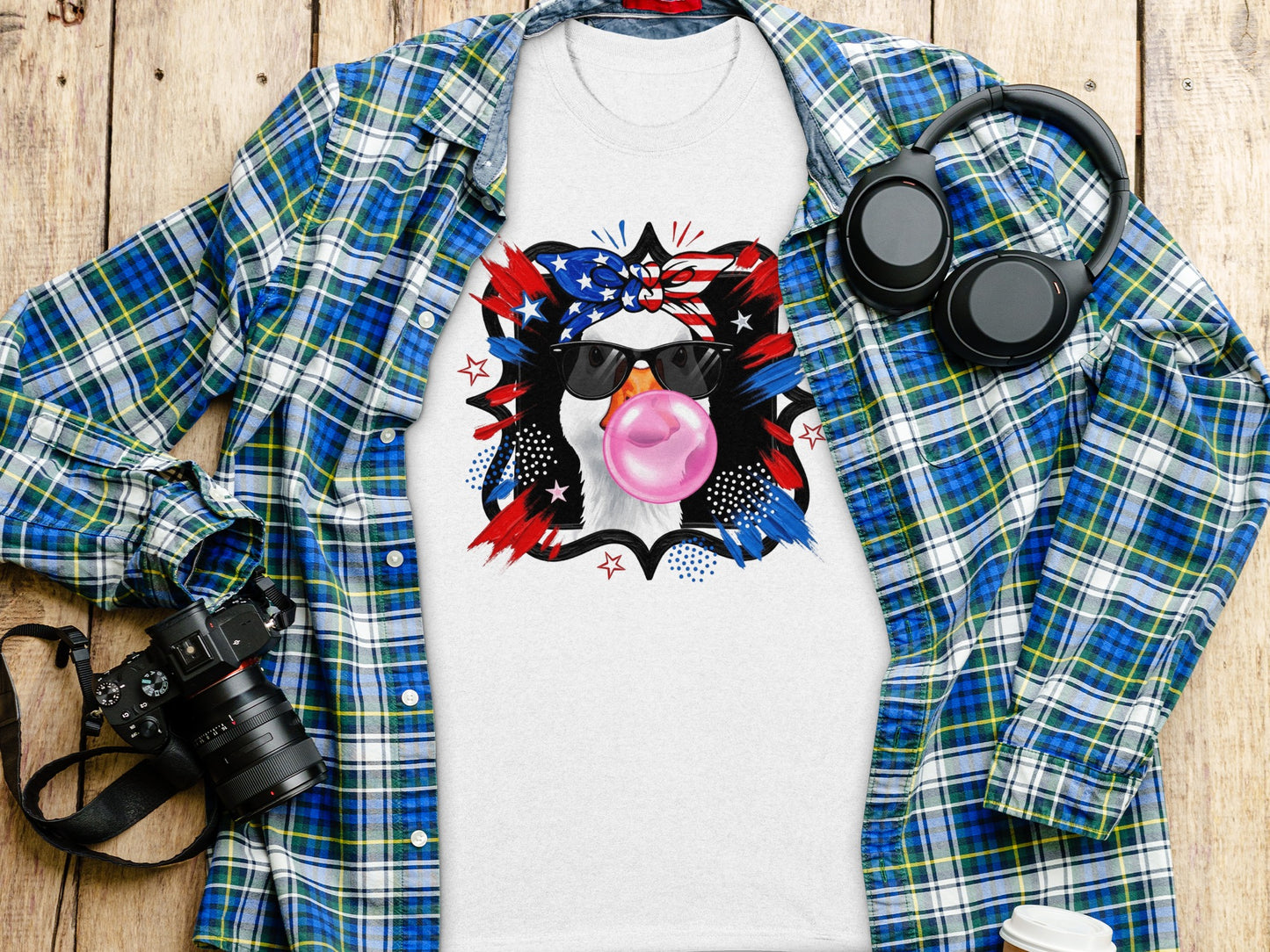 White t-shirt with patriotic duck graphic and sunglasses blowing bubblegum.