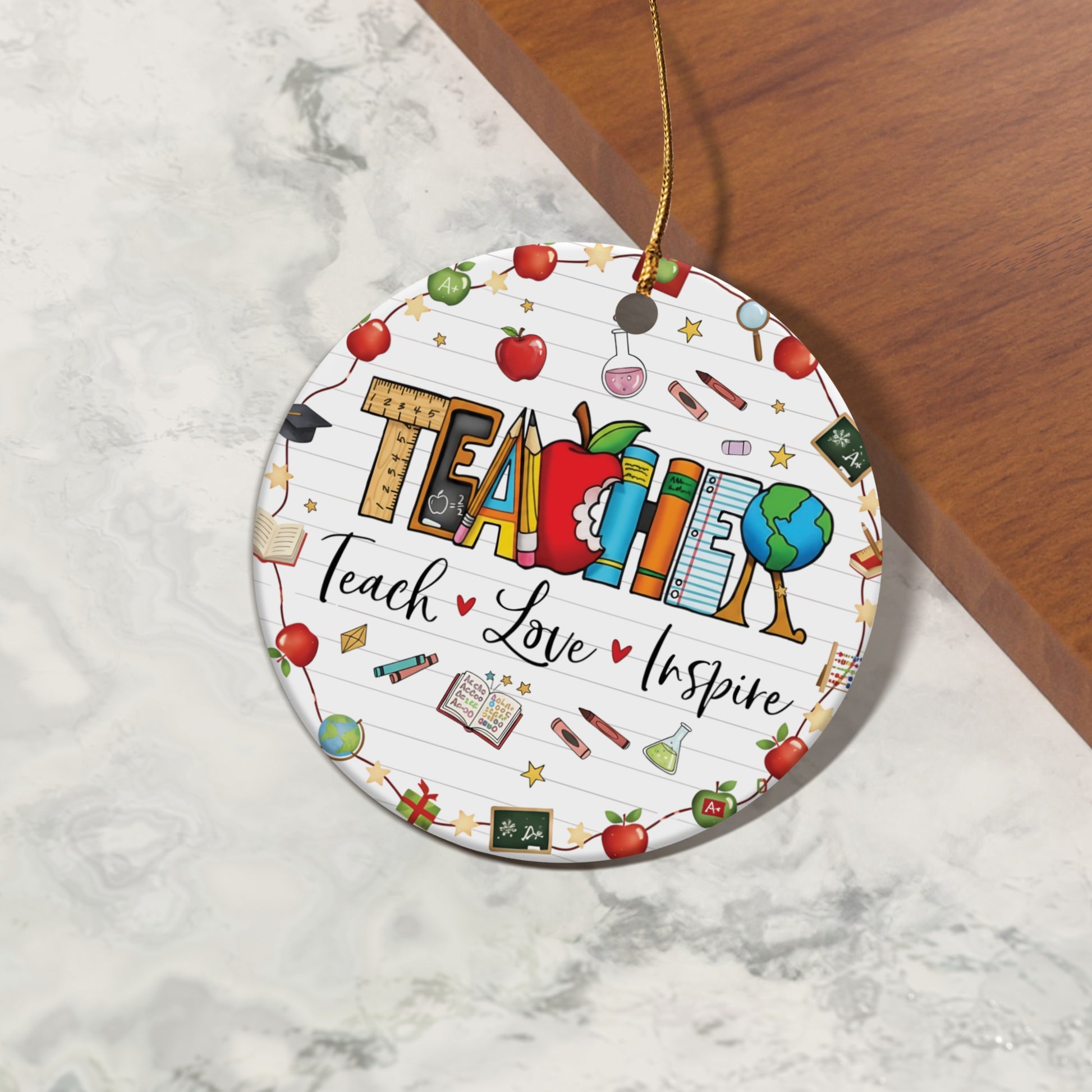 Circular ornament with "TEACHER" and "Teach Love Inspire" surrounded by school supplies.