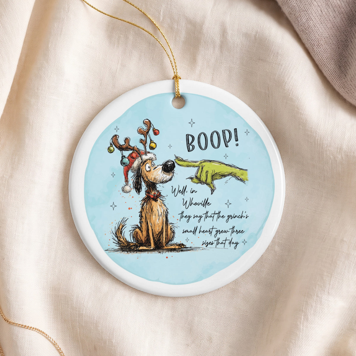 Ornament with dog wearing Santa hat and reindeer antlers, Grinch's finger booping its nose.
