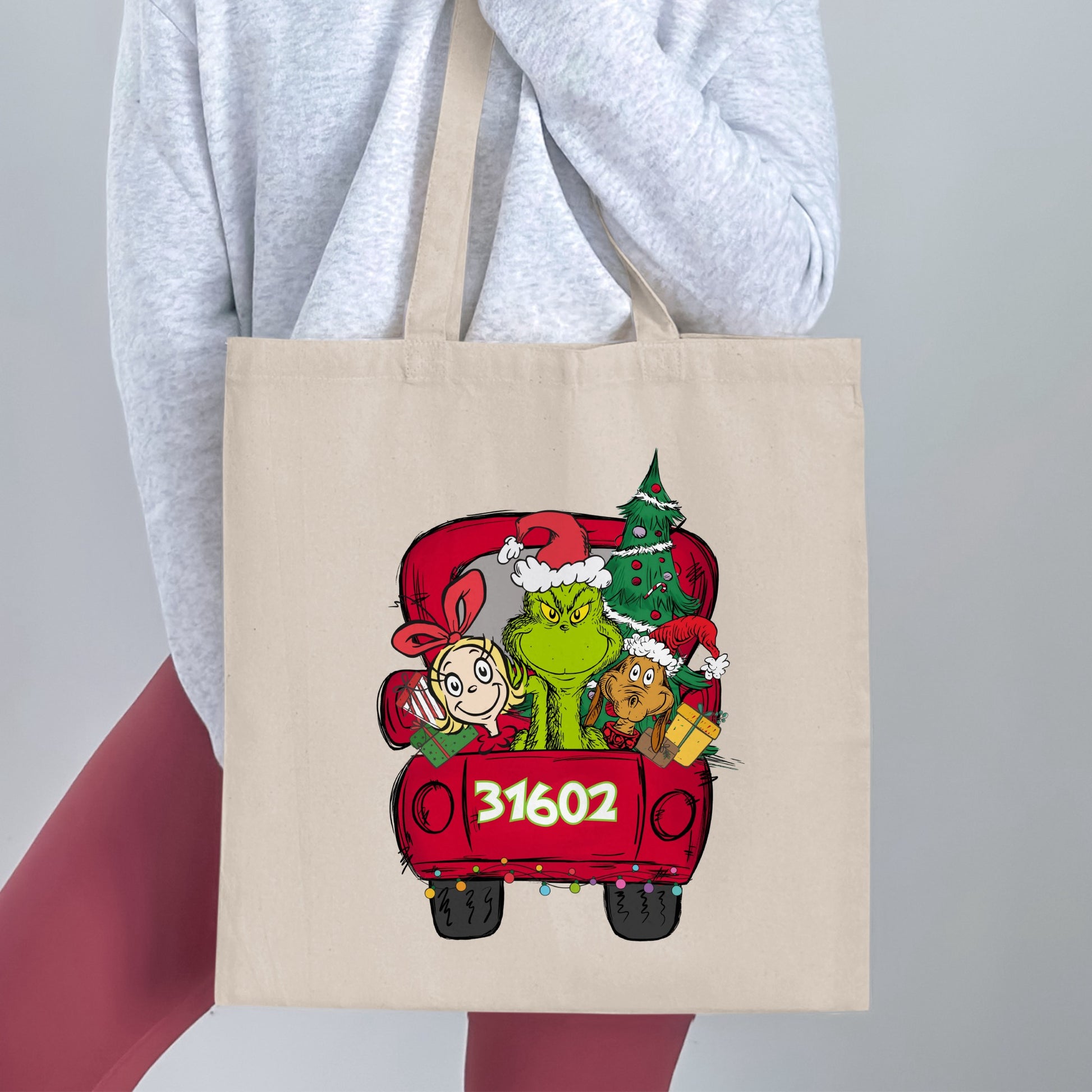 Grinch, Cindy Lou Who, Max, and a Christmas tree in a red truck with "31602"