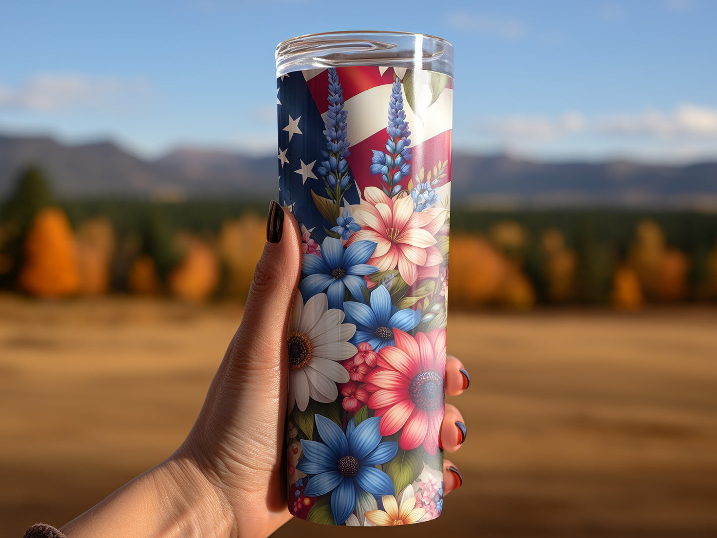 Hand holding a tumbler with an American flag and floral design.