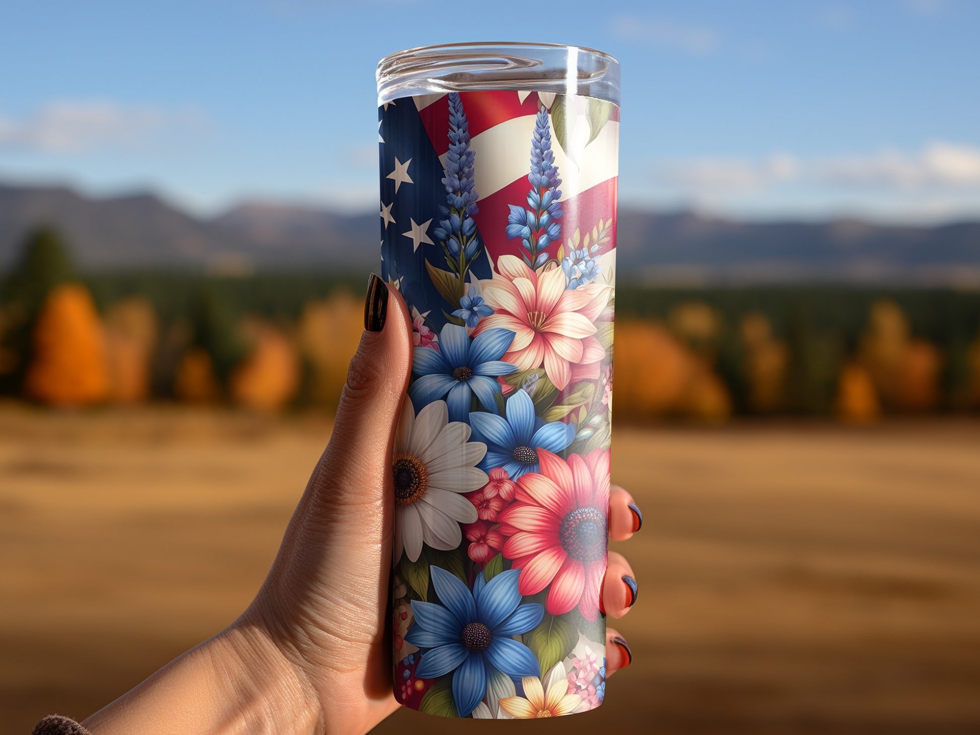 Hand holding a tumbler with an American flag and floral design.